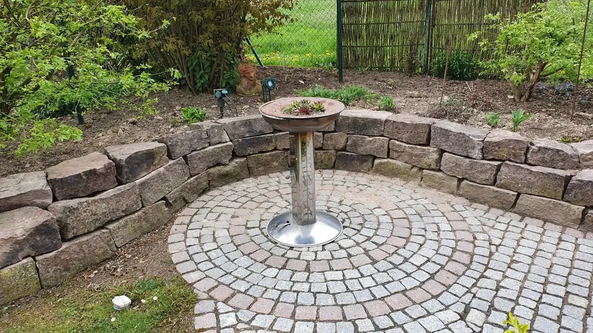 Gepflastertes Rondell mit Natursteineinfassung im Garten