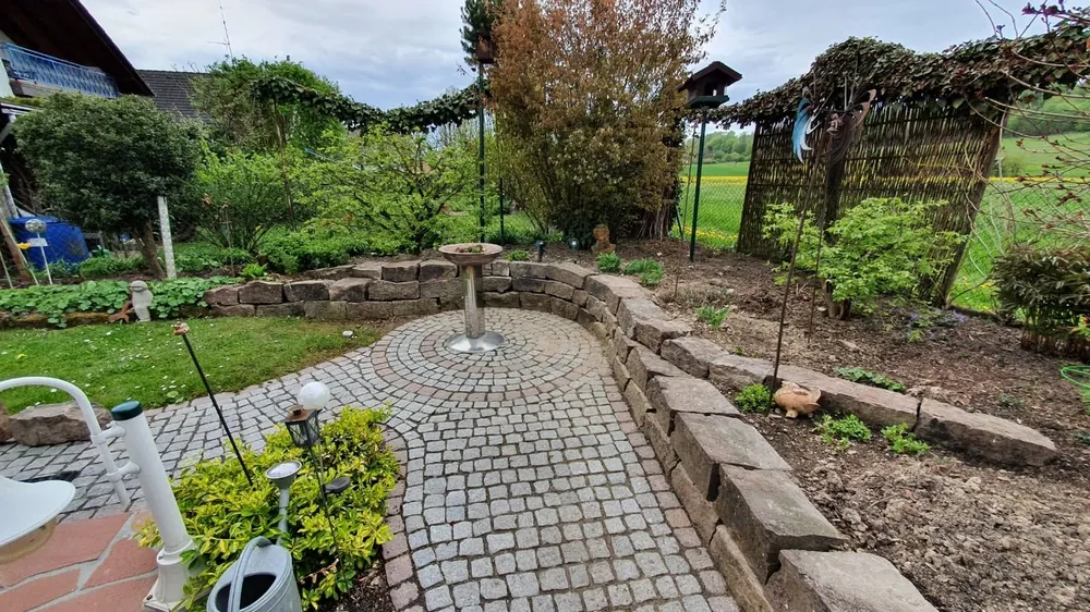 Fertig gepflasterter Gartenweg mit Beeten