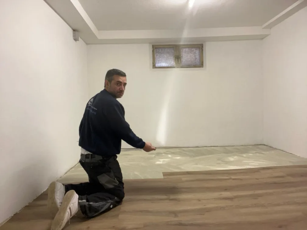 Ein Mitarbeiter verlegt den neuen Boden