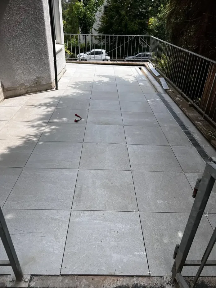 Fertige Terrasse mit großformatigem Belag und Geländer