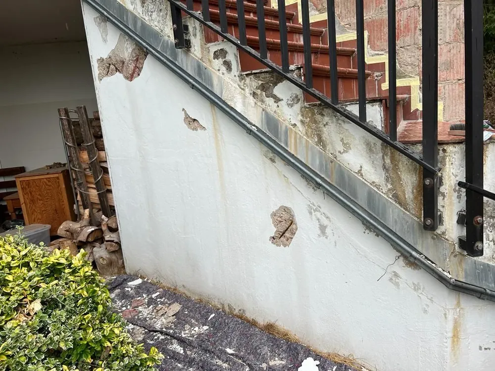 Außentreppe mit beschädigter Wand, vorher